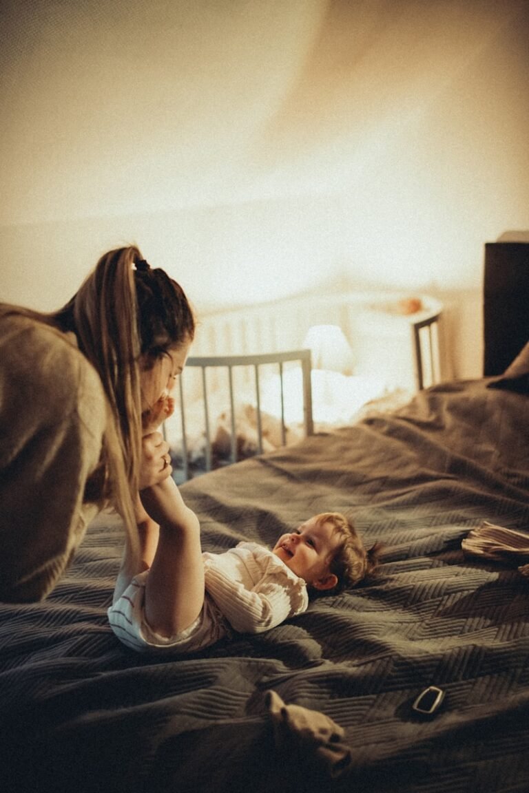 a little girl laying on top of a bed next to a woman